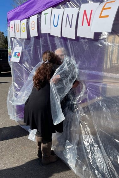 Melissa hugging her grandmother, Dorothy, through the 'hug tunnel,' created to help with elderly isolation during the pandemic.