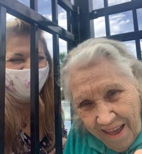 Tina visiting with her mom, but through a gate, unable to physically touch.