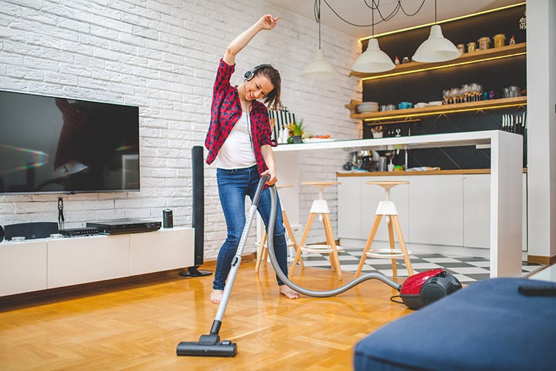 woman dancing while cleaning, a great benefit of music is that it can help motivate you to do what you want to do.