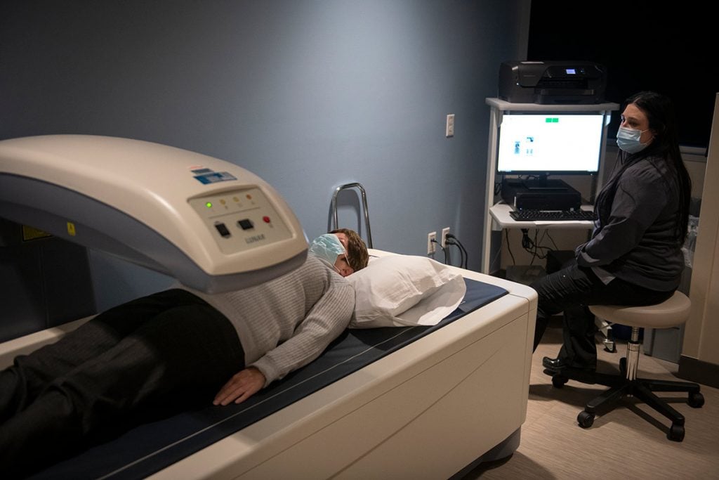 A woman is having a bone density scan in a high-tech machine at UCHealth Grandview Medical Center.