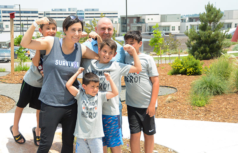 Cathy Pane poses with her husband and four sons after finishing her last chemotherapy treatment for small bowel cancer at UCHealth Highlands Ranch Hospital.