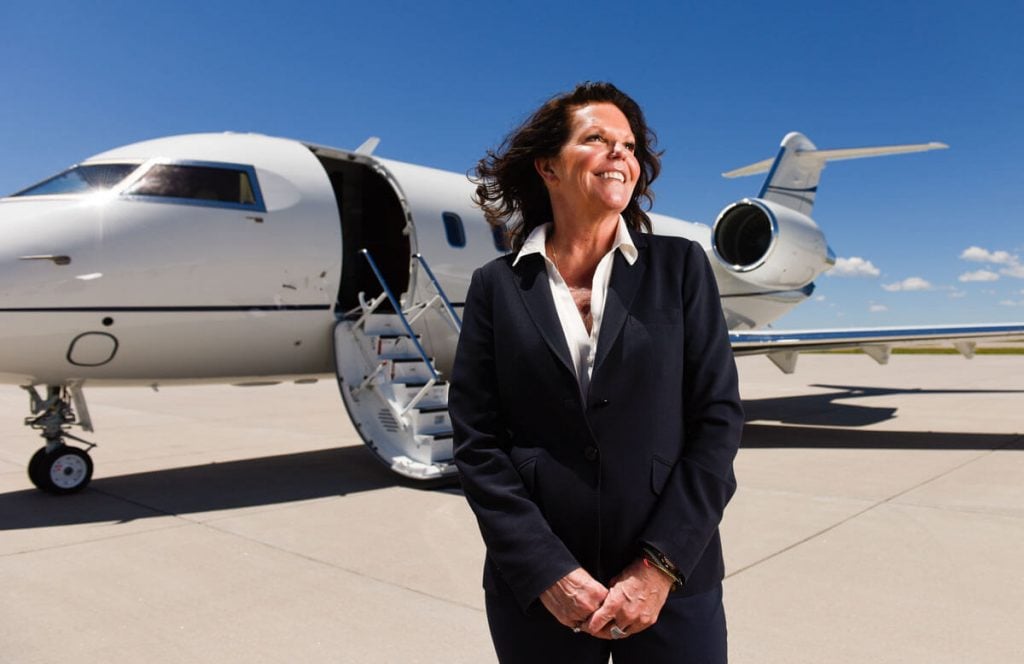 Gail Sadler, a lung cancer patient, on the tarmac outside Modern Aviation where she works at Centennial Airport.