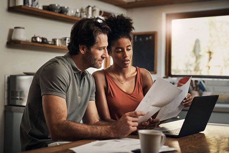 young couple looking over information about colorado open enrollment for health insurance.