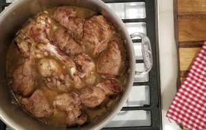 A pan filled with meat and braise.