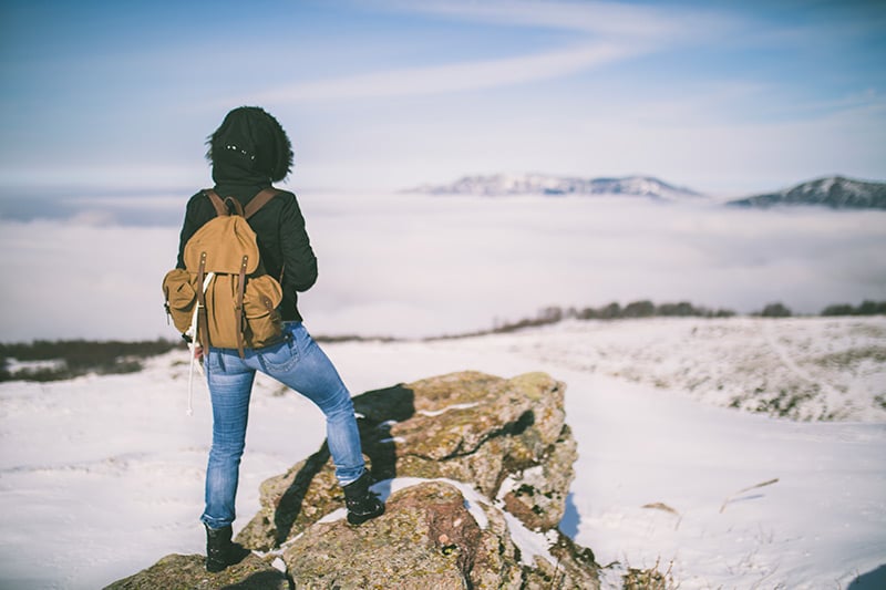 Hiker looks out over a snowy scene, wondering if COVID will ever end.Photo: Getty Images.