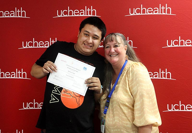 Intern Nathanial Vigil poses with Project SEARCH instructor Karen Galvin during a special event for the interns at the hospital on May 5, 2022. Photo by Kati Blocker, UCHealth.
