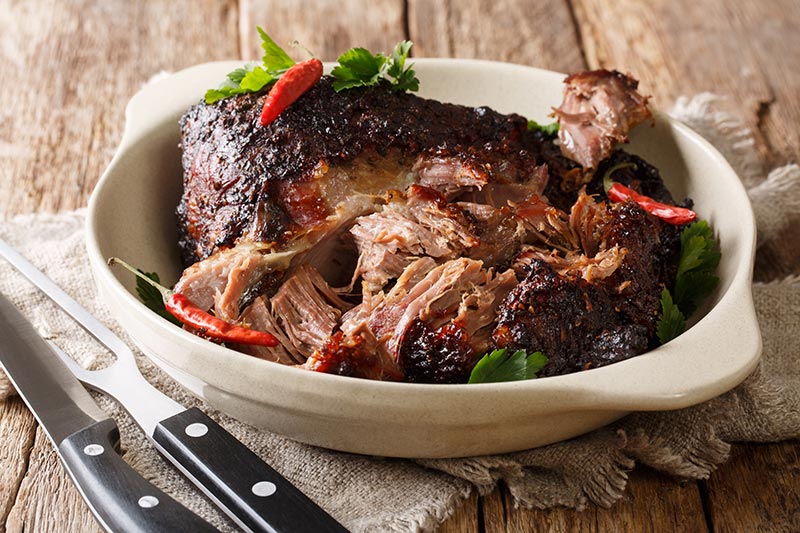 This pernil, a slow-roasted pork shoulder, is tender and juicy. A great recipe for your next meal. Photo: Getty Images.