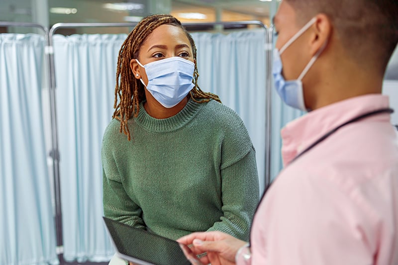 The BA.5 COVID-19 variant is spreading widely. Here, a woman in a mask sees her doctor. Photo: Getty Images.