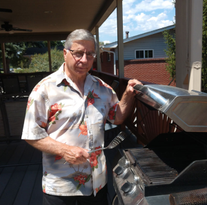 Steve, who was the first patient to enroll in the inspiratory muscle strength training study and completed it in late July 2022, stands in front of a grill..