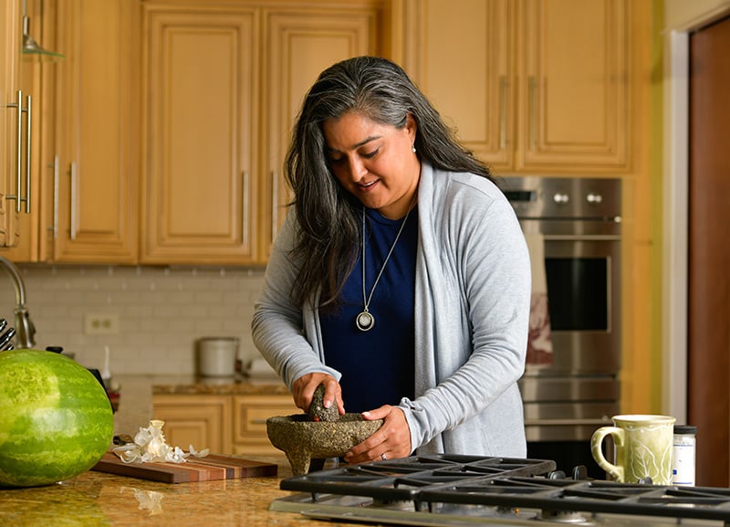 Dr. Abbey Lara making salsa with her grandmother's molcajete.