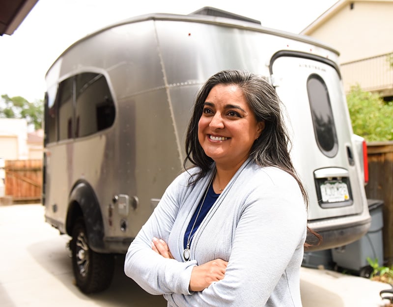 Dr. Abbey Lara loves camping and hunting. Here, she poses with the Airstream travel trailer that she and her husband purchased during the pandemic. Photo by Cyrus McCrimmon for UCHealth.