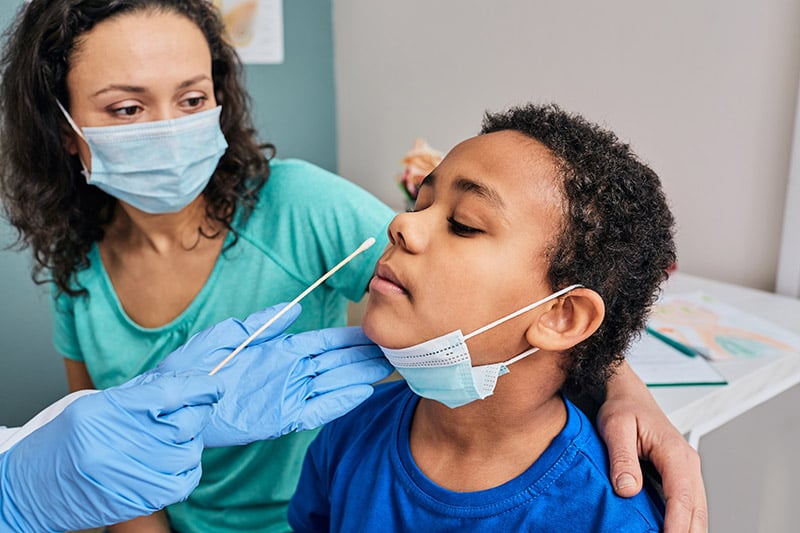mom with her son who is getting tested for COVID-19.