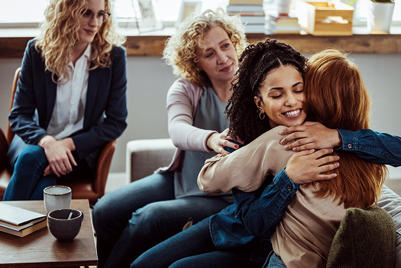 Women hug during a support group meeting. There are three stages of recovery.