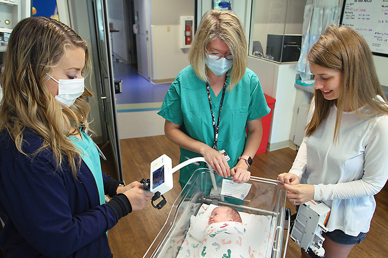 UCHealth NICU nurses Tracy Stefanik and NAME, adjust baby Mason's bedside camera, with his mother, Erin Ecker, by his side in the UCHealth Poudre Valley Hospital Neonatal Intensive Care Unit recently. Photo by Joel Blocker, for UCHealth.