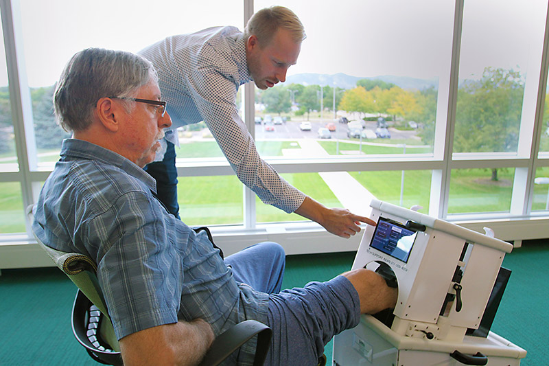 Kevin Labus, center, a research scientist with CSU and co-investigator on the tibia study, and William Snodgrass, a former patient, demonstrate how the CSU-invented device used in tibia fracture research, works.