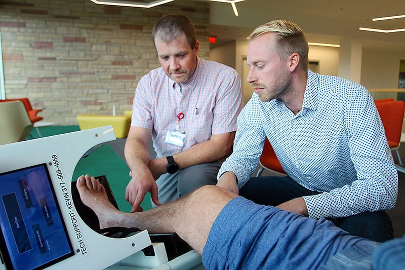 Nikiah Nudell, left, manager of the trauma research team at Medical Center of the Rockies, and Kevin Labus, research scientist with CSU and study co-investigator, use a CSU-invented device on a patients leg as part of research on tibia fractures.
