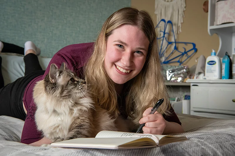 Aubriana Winters' favorite pastimes include writing in her journals and spending time with her cat, Purrsie. She's also getting great work experience as an intern at UCHealth Memorial Hospital Central in Colorado Springs. Aubriana works four days a week at one of the registration desks as part of Project SEARCH, a school-to-work transition program for young adults with intellectual and developmental disabilities. Photo by Chuck Bigger, for UCHealth.